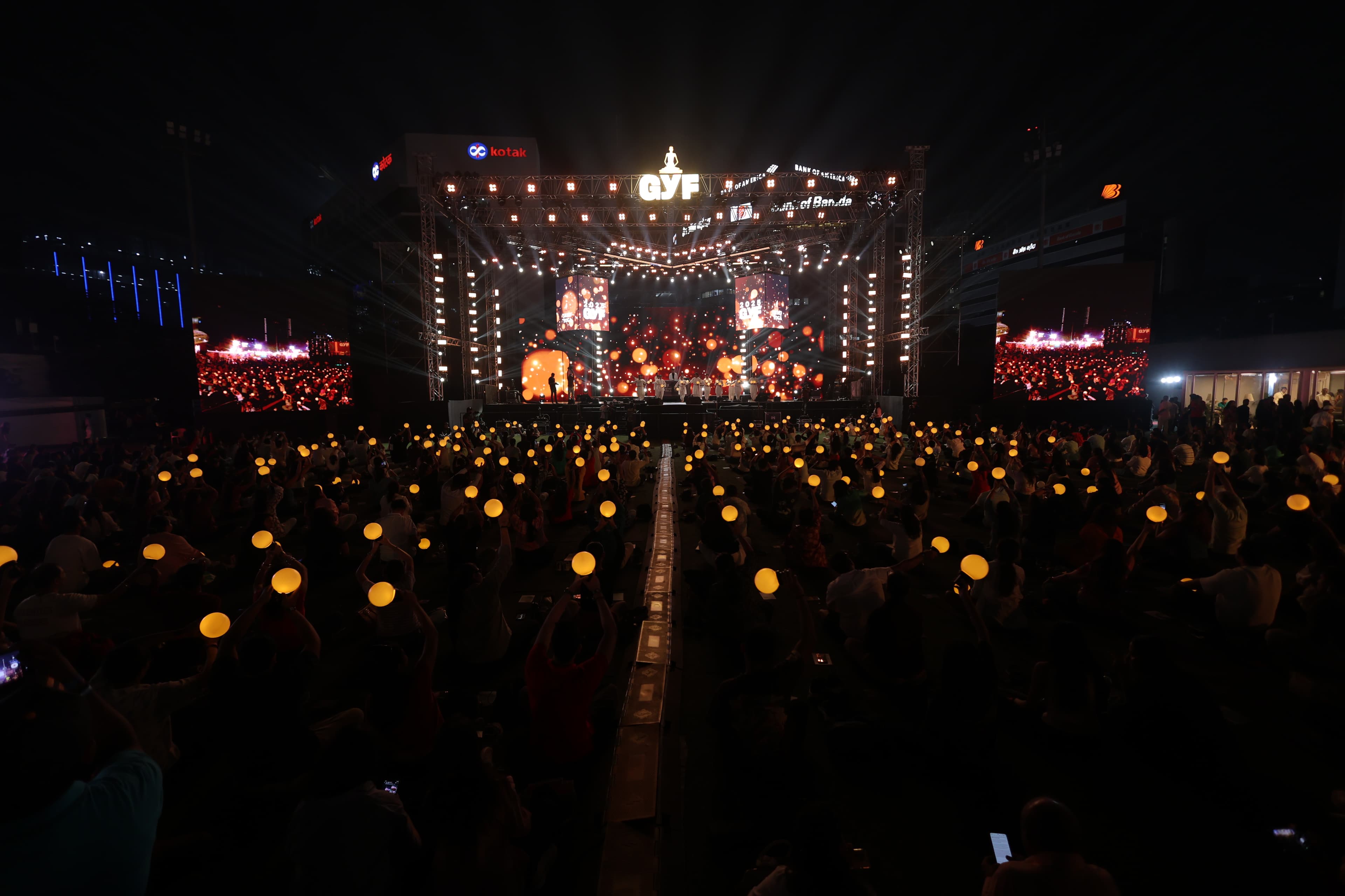 Festival participants hold illuminated moons in front of the GYF stage