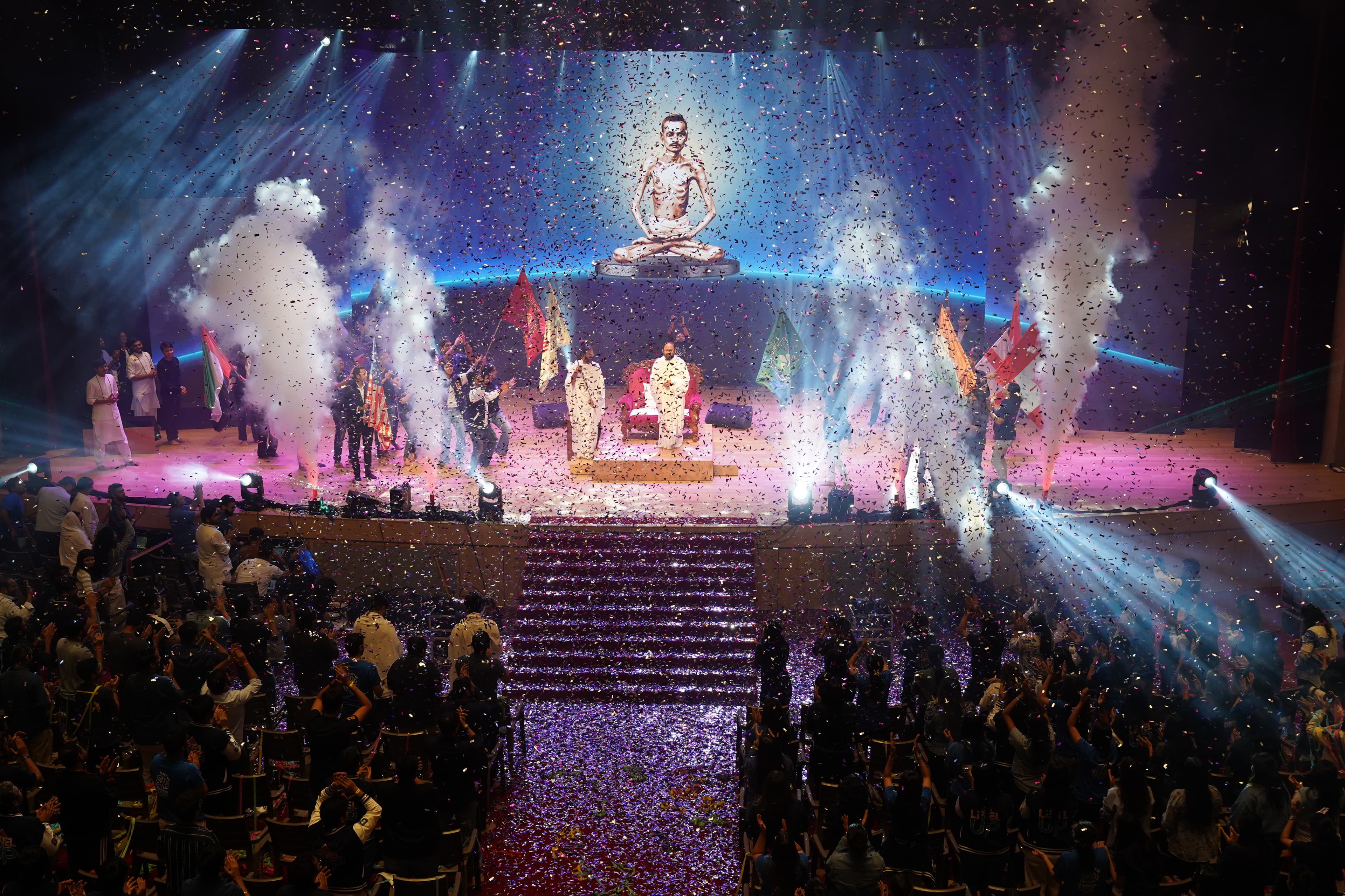 Pujya Gurudevshri on the Dharampur festival stage amid flags, light and confetti