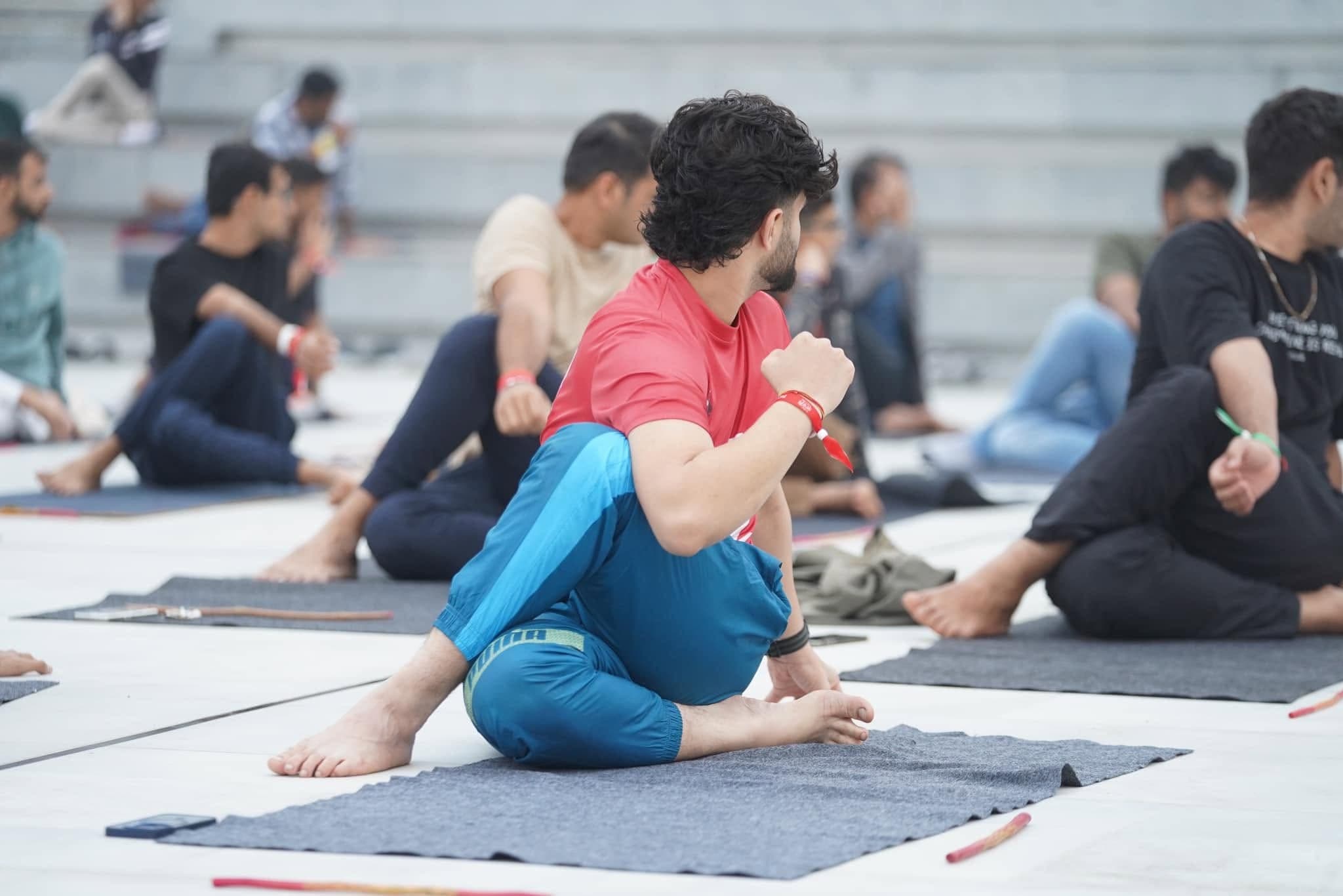 Participants practice a seated stretch outdoors during the 2024 festival